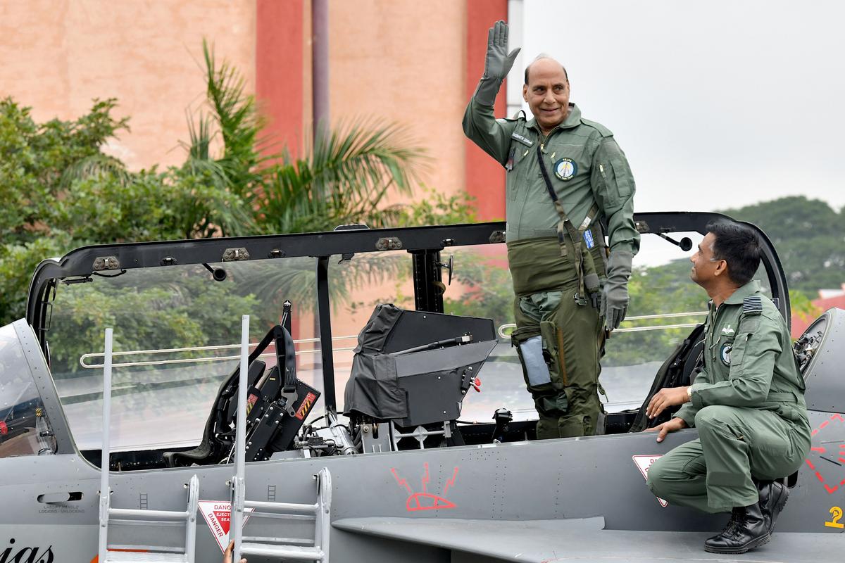Indian Defense Minister Rajnath Singh waves to the media from the co-pilot seat before flying on a sortie in a Tejas Light Combat Aircraft (LCA) at HAL Airport in Bangalore on Sept. 19, 2019. Tejas is India's indigenously built aircraft. (Manjunath Kiran /AFP via Getty Images)