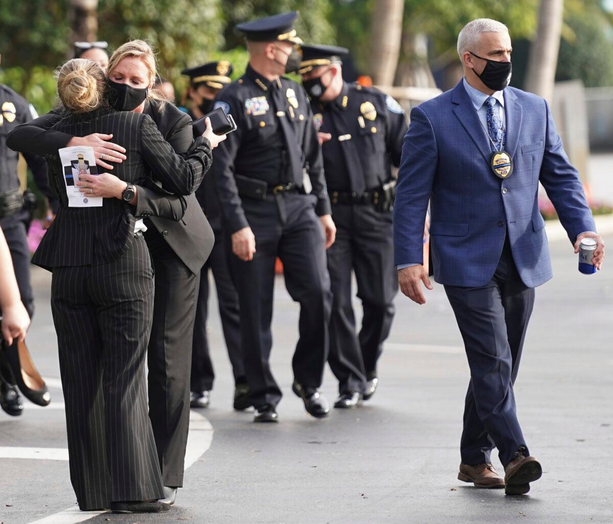 Law enforcement representatives embrace as they leave a memorial service for Special Agent Laura Schwartzenberger, in Miami Gardens, Fla., on Feb. 6, 2021. (Hans Deryk/AP Photo)