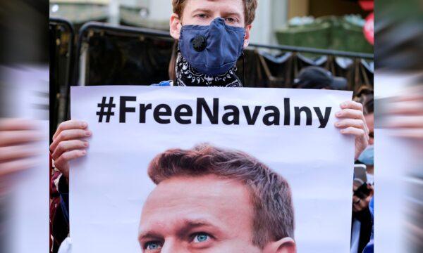 A protester wearing a face mask holds a poster during a demonstration in support of Russian opposition leader Alexei Navalny, who was sentenced to jail, in Los Angeles, California, U.S., on Feb. 6, 2021. (Ringo Chiu/Reuters)