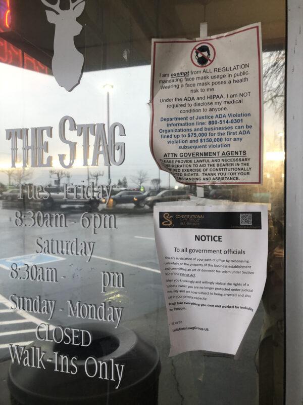Two notices posted outside Stag Barber & Styling, on Feb. 2, 2021. (Echo Liu/The Epoch Times)