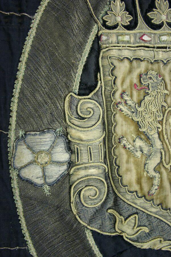 The coat of arms, on the right, is thought to have been embroidered at a workshop. (Rachel Langley/National Trust)
