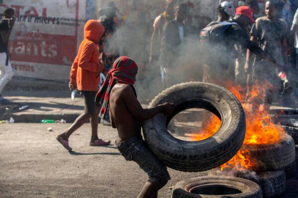 A protester sets up a burning barricade during a protest to demand the resignation of Haitian President Jovenel Moise in Port-au-Prince, Haiti, on Feb. 7, 2021. (Dieu Nalio Chery/AP Photo)