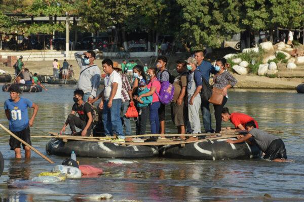 People cross the Suchiate River on a raft from Guatemala to Ciudad Hidalgo, Mexico on Jan. 18, 2021, as a new migrant caravan, mostly of Hondurans heading to the United States is expected to arrive. (Isaac Guzman/AFP via Getty Images)