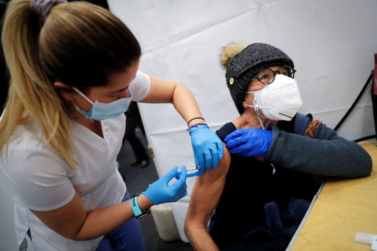 A health care worker administers a shot of a COVID-19 vaccine to a woman in New York City, on Jan. 29, 2021. (Mike Segar/Reuters)
