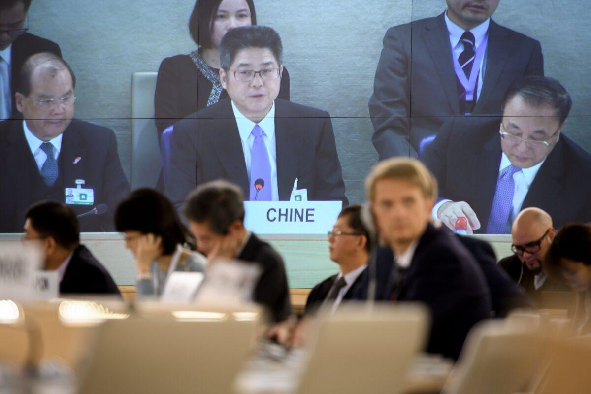 Chinese Vice Minister of Foreign Affairs Le Yucheng (C) is seen on a giant TV screen delivering a speech before the United Nations (UN) Human Rights Council in Geneva on Nov. 6, 2018. (Fabrice Coffrini/AFP via Getty Images)