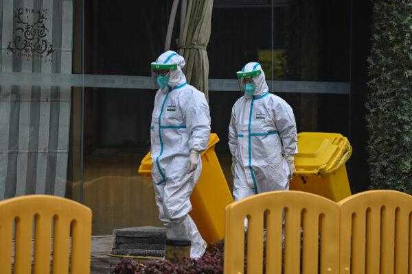 Workers wearing protective gear are seen in the compounds of The Jade Boutique Hotel, where members of the World Health Organization (WHO) team investigating the origins of the COVID-19 pandemic were due to complete their quarantine, in Wuhan, China, on Jan. 28, 2021. (Hector Retamal/AFP via Getty Images)