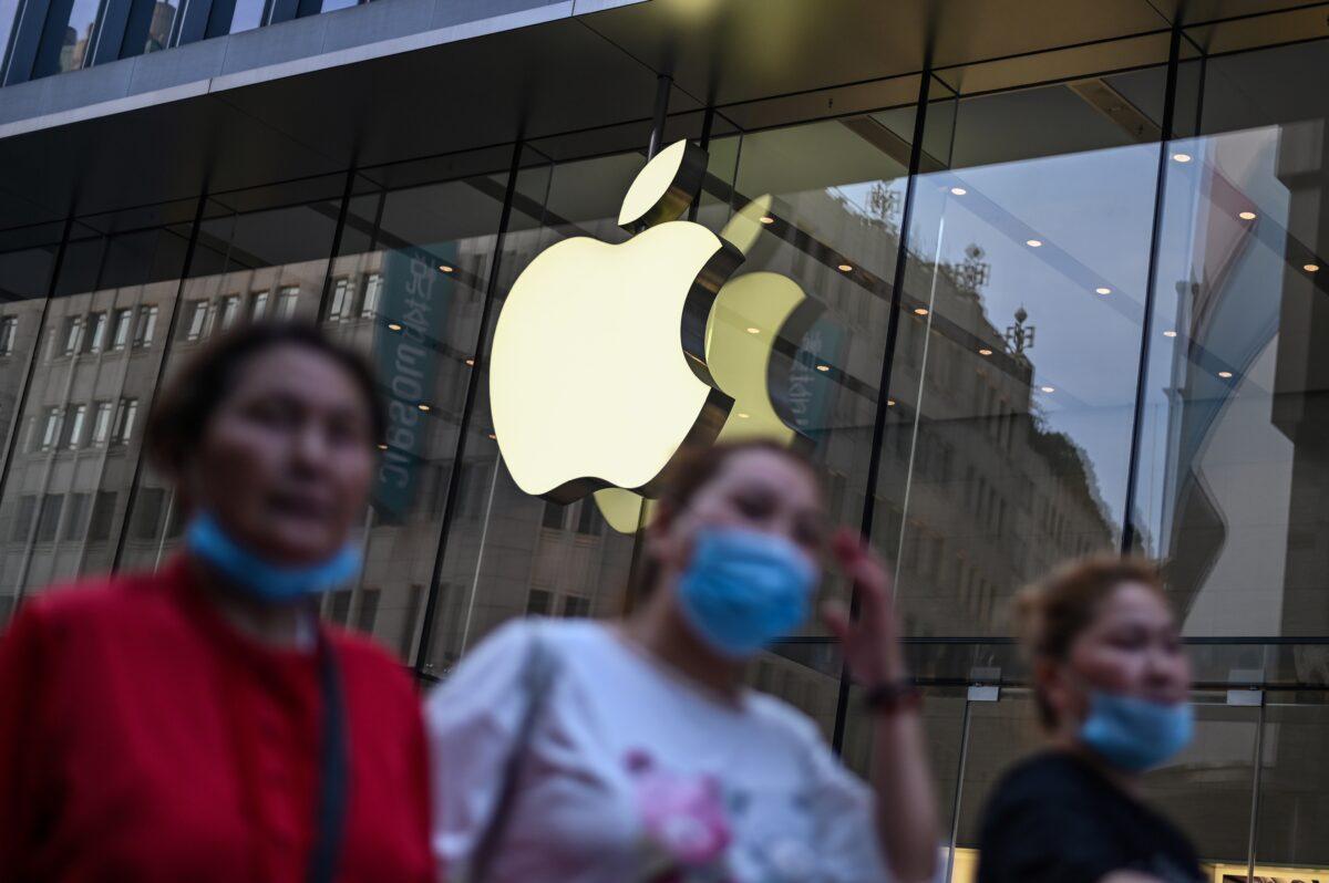 People wearing face masks walk past an Apple store in Shanghai on June 2, 2020. (Hector Retamal/AFP via Getty Images)