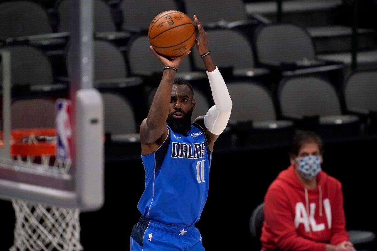 Dallas Mavericks forward Tim Hardaway Jr. (11) shoots as team owner Mark Cuban watches during the first half of the team's NBA basketball game against the Golden State Warriors in Dallas, Texas, on Feb. 4, 2021. (Tony Gutierrez/AP Photo)