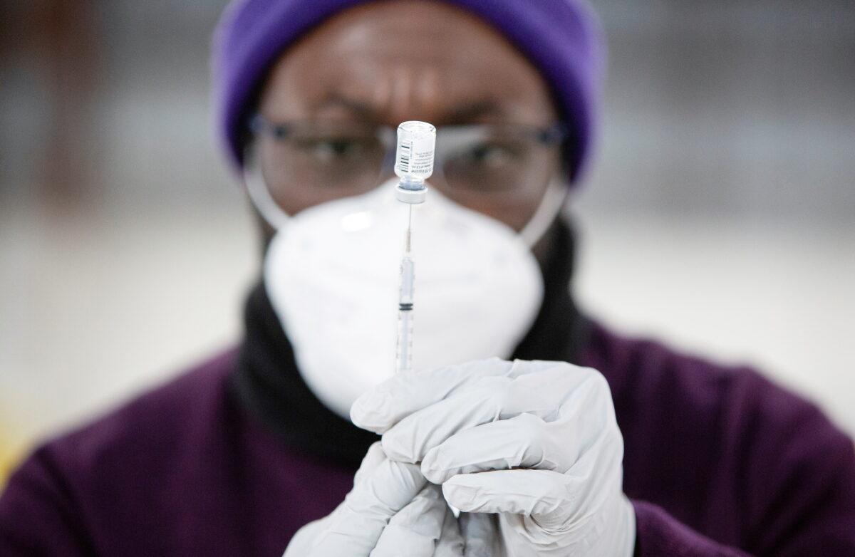 Safeway pharmacy manager Kel Fanny draws up a COVID-19 vaccine at a mass vaccination site at the Clark County Event Center at the Fairgrounds in Ridgefield, Wash., on Jan. 27, 2021. (Alisha Jucevic/Reuters)