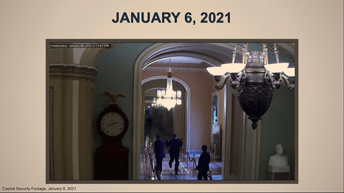 In this image from video, a security video shows U.S. Capitol Police officer Eugene Goodman running past Sen. Mitt Romney (R-Utah), left, as House impeachment manager Del. Stacey Plaskett (D-Virgin Islands) speaks during the second impeachment trial of former President Donald Trump in the Senate at the U.S. Capitol in Washington on Feb. 10, 2021. (Senate Television via AP)