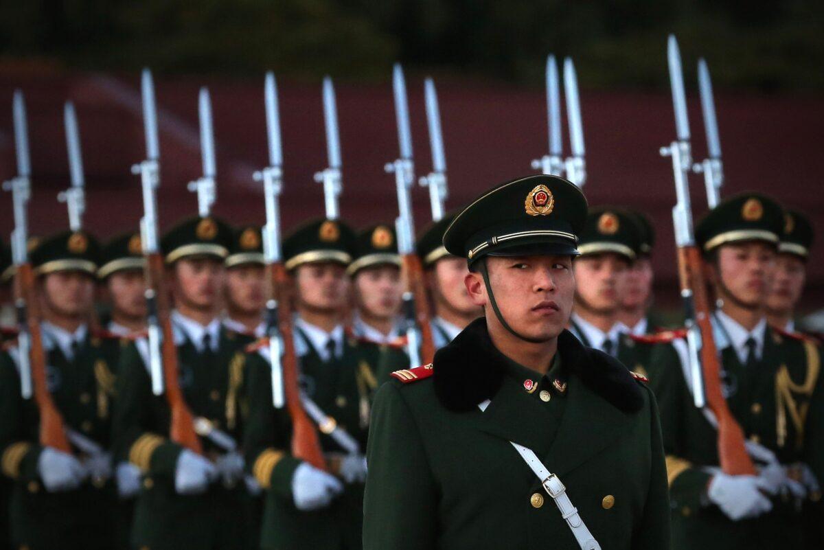 A paramilitary police officer stands guard during the flag-lowering ceremony at Tiananmen Square in Beijing on Nov. 13, 2012. (Feng Li/Getty Images)
