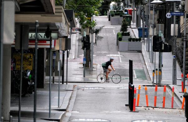A man cycles along a street in Melbourne, Australia, on Feb. 13, 2021. (Luis Ascui/Getty Images)