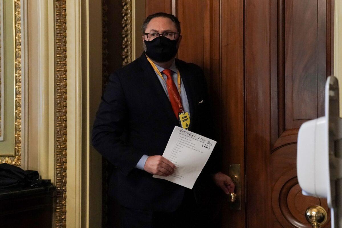 Jason Miller, adviser to former President Donald Trump, carries a witness list to the Senate Chamber during the fifth day of the impeachment trial of former President Donald Trump on Capitol Hill in Washington on Feb. 13, 2021. (Greg Nash - Pool/Getty Images)