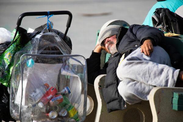 A homeless man sleeps on a bench in the Venice neighborhood of Los Angeles on Jan. 27, 2021. (John Fredricks/The Epoch Times)