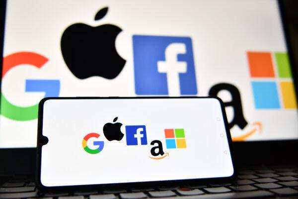 An illustration file photograph shows the logos of Google, Apple, Facebook, Amazon, and Microsoft displayed on a mobile phone and a laptop screen. (Justin Tallis/AFP via Getty Images)