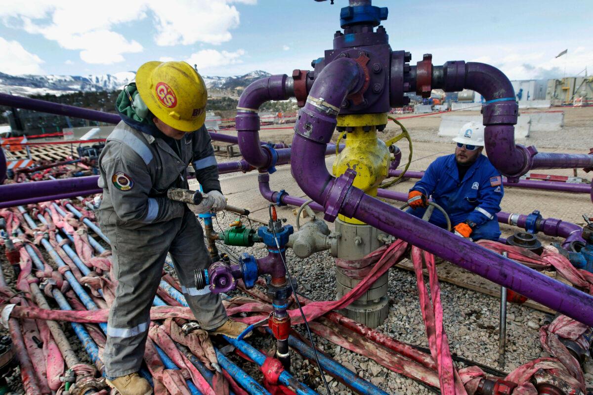 Workers tend to a well head during a hydraulic fracturing operation outside Rifle, Colo., on March 29, 2013. (Brennan Linsley/AP Photo)