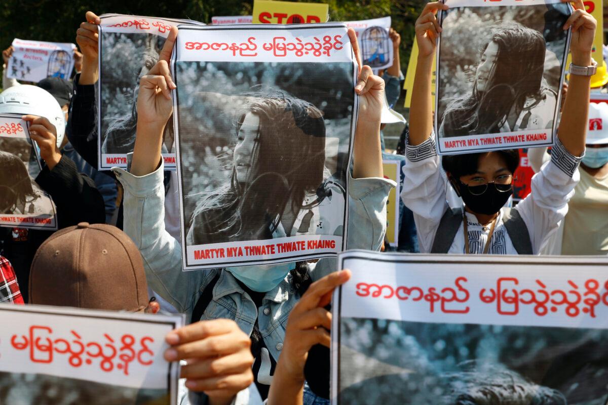 Mandalay University graduates hold posters with an image of Mya Thwate Thwate Khaing, a 19-year old woman shot by police on Feb. 9 in Naypyitaw, during an anti-coup protest in Mandalay, Burma, on Feb. 14, 2021. (AP Photo)