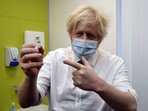 Britain's Prime Minister Boris Johnson holds a vial of the AstraZeneca vaccine during a visit to a COVID-19 vaccination centre at the Health and Well-being Centre in Orpington, south-east London on Feb. 15, 2021. (Jeremy Selwyn/Pool Photo via AP)