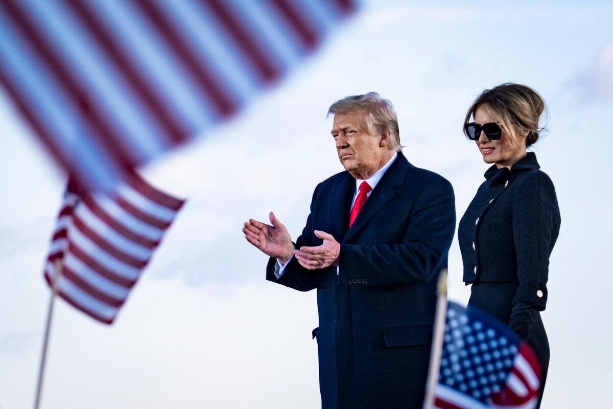 President Donald Trump and First Lady Melania Trump on stage after speaking to supporters at Joint Base Andrews before boarding Air Force One for his last time as president in Joint Base Andrews, Md., on Jan. 20, 2021. (Pete Marovich/Pool/Getty Images)