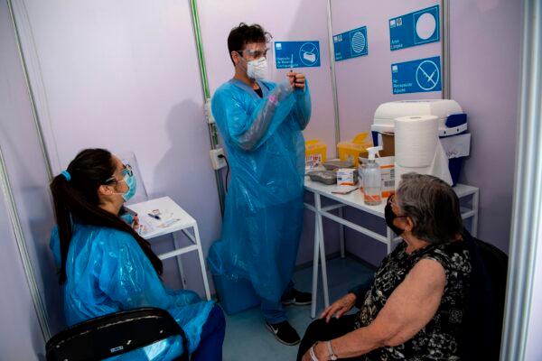 A health care worker prepares to administer a dose of China's Sinovac CoronaVac vaccine to a person at a vaccination center mounted at the Bicentenario Stadium in Santiago, Chile, on Feb. 3, 2021. (MARTIN BERNETTI/AFP via Getty Images)