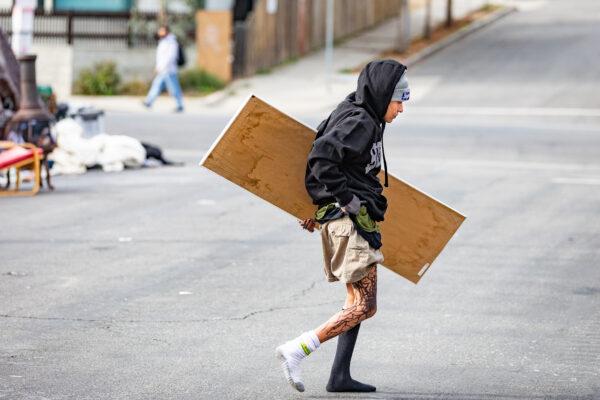 A homeless person walks across 3rd Street in the Venice neighborhood of Los Angeles on Jan. 27, 2021. (John Fredricks/The Epoch Times)