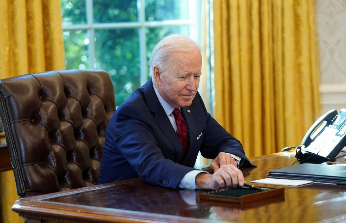 President Joe Biden puts down his pen after signing executive orders relating to health care, at the White House on Jan. 28, 2021. (Kevin Lamarque/Reuters)