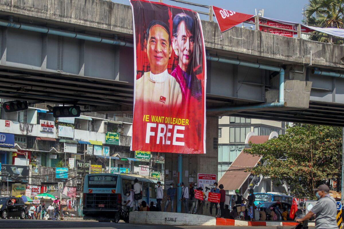 Pictures of detained Burma President Win Myint and leader Aung San Suu Kyi are displayed at an intersection against the military coup in Yangon, Burma, on Feb. 16, 2021. (AP Photo)