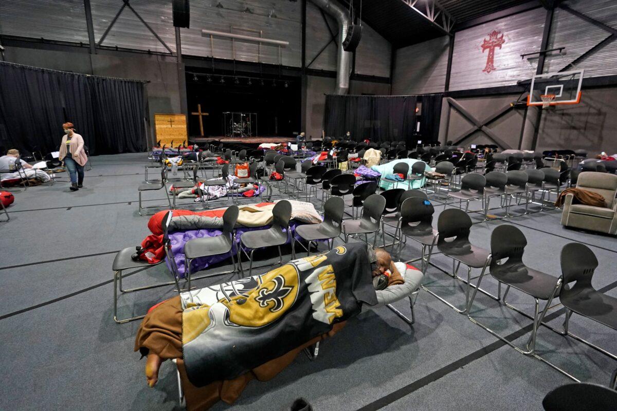 People seeking shelter from below freezing temperatures rest inside a church warming center in Houston, Texas, on Feb. 16, 2021. (David J. Phillip/AP Photo)