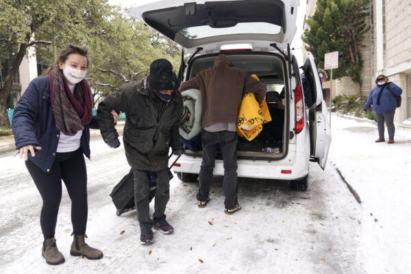 Morgan Handley (L) helps move people to a warming shelter at Travis Park Methodist Church to help escape sub-freezing temperatures in San Antonio on Feb. 16, 2021. (Eric Gay/AP Photo)