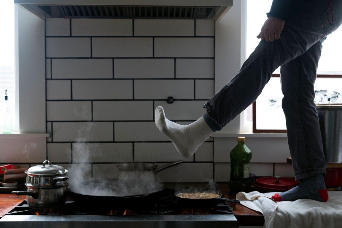 Jorge Sanhueza-Lyon stands on his kitchen counter to warm his feet over his gas stove in Austin, Texas, on Feb. 16, 2021. (Ashley Landis/AP Photo)