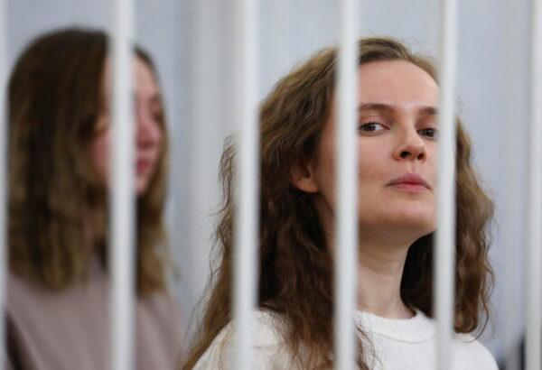 Katsiaryna Andreyeva and Darya Chultsova stand inside a defendants' cage during a court hearing in Minsk on Feb. 18, 2021. (Stringer/Reuters)