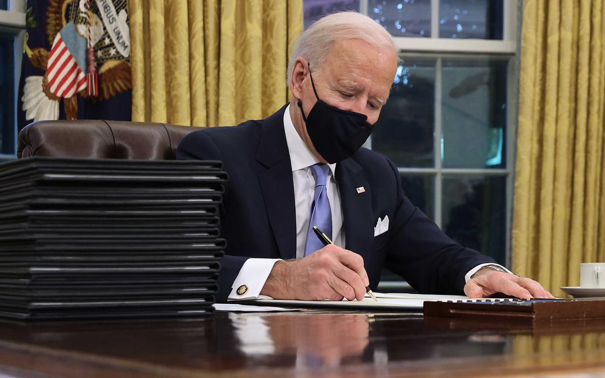 President Joe Biden signs a series of executive orders at the Resolute Desk in the Oval Office just hours after his inauguration in Washington on Jan. 20, 2021. (Chip Somodevilla/Getty Images)