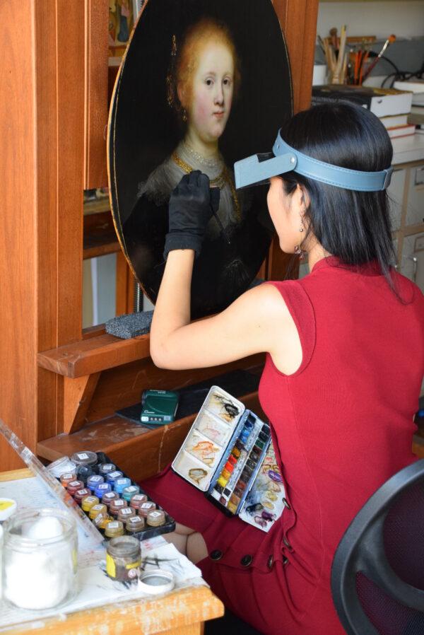 Conservator Shan Kuang working on Rembrandt's "Portrait of a Young Woman" at the  Conservation Center of the Institute of Fine Arts at New York University. (Allentown Art Museum)