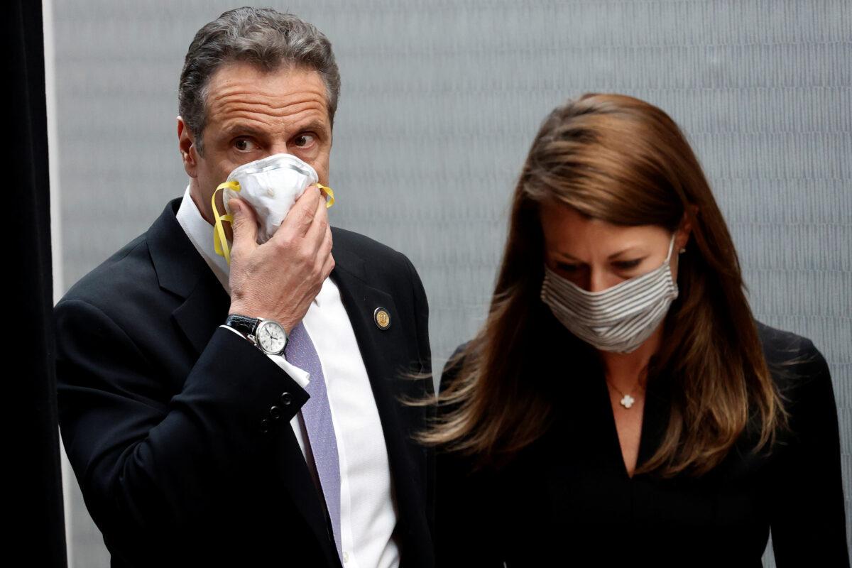 New York Gov. Andrew Cuomo holds a protective mask to his face as he and Secretary to the Governor Melissa DeRosa arrive for a briefing at New York Medical College in Valhalla, New York, on May 7, 2020. (Mike Segar/Reuters)