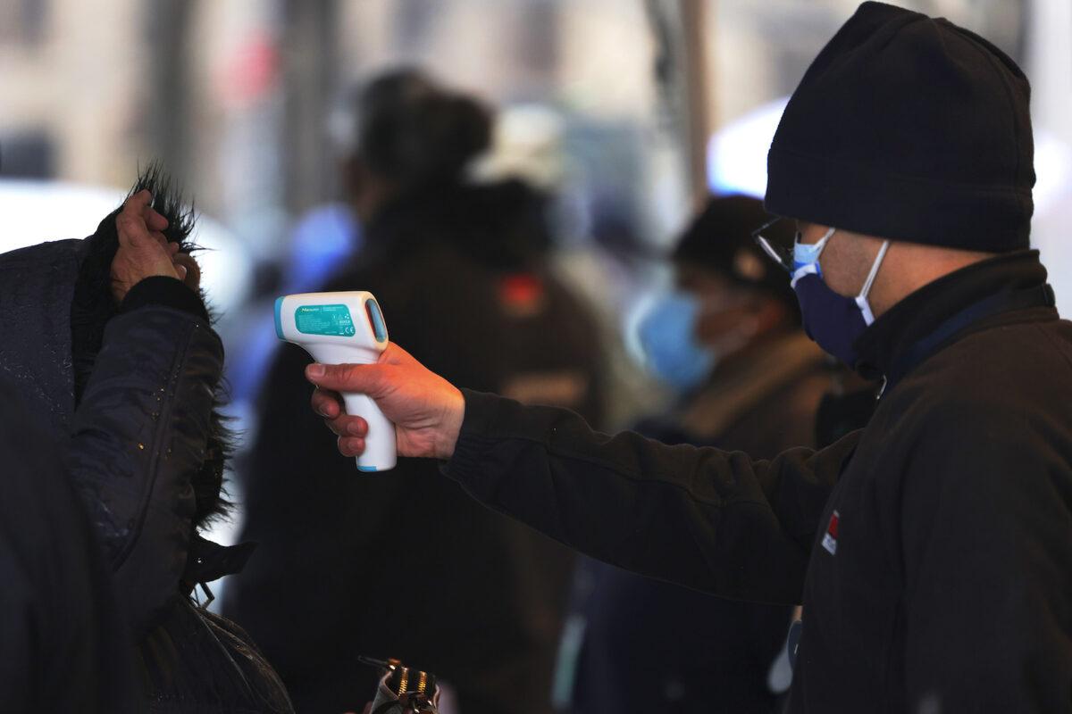 A person has their temperature checked as they prepare to enter a building in the Bronx borough of New York City on Feb. 05, 2021. (Michael M. Santiago/Getty Images)