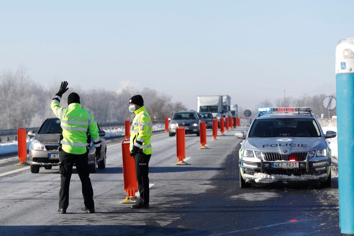 Policemen stop a car to check documents of a driver near the city of Sokolov, Czech Republic on Feb. 12, 2021. The Czech government has decided to further tighten restrictive measures amid a surge of a highly contagious coronavirus variant in one of the hardest-hit European Union's nations. (Petr David Josek/AP Photo/File)