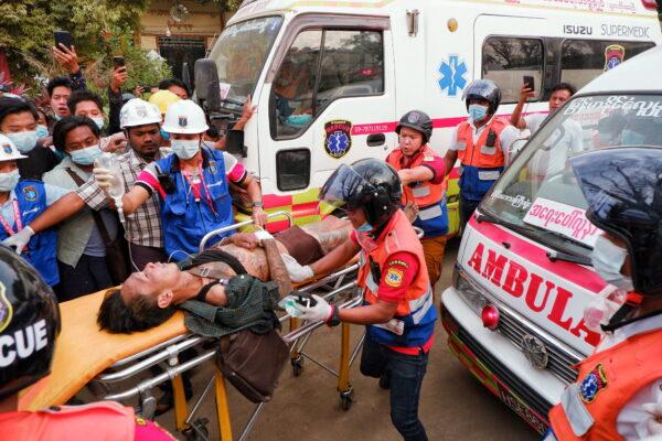 An injured man is carried by rescue workers after protests against the military coup, in Mandalay, Burma, on Feb. 20, 2021. (Stringer/Reuters)