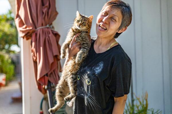 Han Tran holds one of her rescued cats in her yard in Garden Grove, Calif., on Feb. 19, 2021. (John Fredricks/The Epoch Times)
