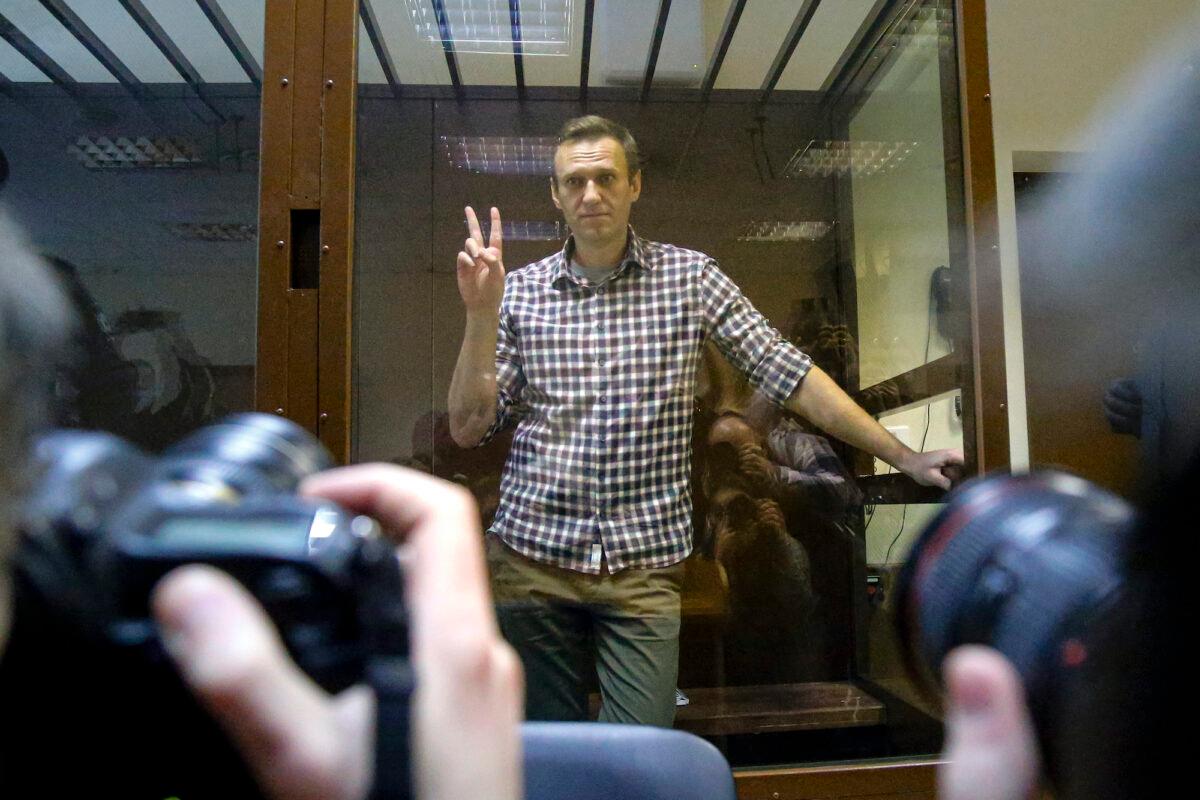 Russian opposition leader Alexei Navalny gestures posing for photographers as he stands in a cage in the Babuskinsky District Court in Moscow, Russia, Saturday, Feb. 20, 2021. (Alexander Zemlianichenko/AP)