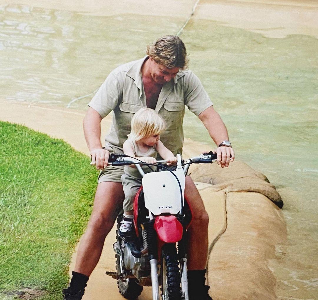 Robert Irwin as a toddler sitting on the trail bike, clinging onto the handlebars as Steve Irwin rides. (Courtesy of <a href="https://www.instagram.com/robertirwinphotography/">Robert Irwin</a> via <a href="https://www.facebook.com/AustraliaZoo">Australia Zoo</a>)