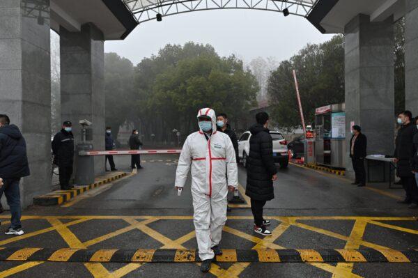 A guard wears protective gear as he stands at the entrance to the Hubei provincial centre for disease control and prevention while members of the World Health Organization (WHO) team investigating the origins of COVID-19 visit the centre in Wuhan, China, on Feb. 1, 2021. (Hector Retamal/AFP via Getty Images)