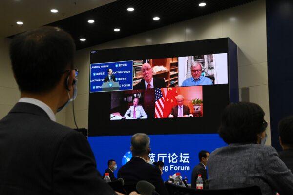 Guests including Former US treasury secretary Henry Paulson (top C), former Australian prime minister Kevin Rudd (top R), Chinese Ambassador to the US Cui Tiankai (bottom R) are seen on a screen via a live video link at the Lanting Forum on China-US relations in Beijing on Feb. 22, 2021. (Greg Baker/AFP via Getty Images)
