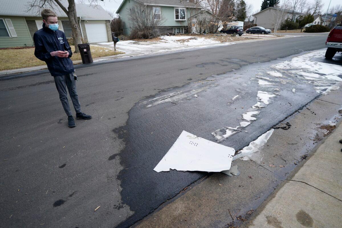 A man looks over debris that fell off a plane as it shed parts over a neighborhood in Broomfield, Colo., on Feb. 20, 2021. (David Zalubowski/AP Photo)
