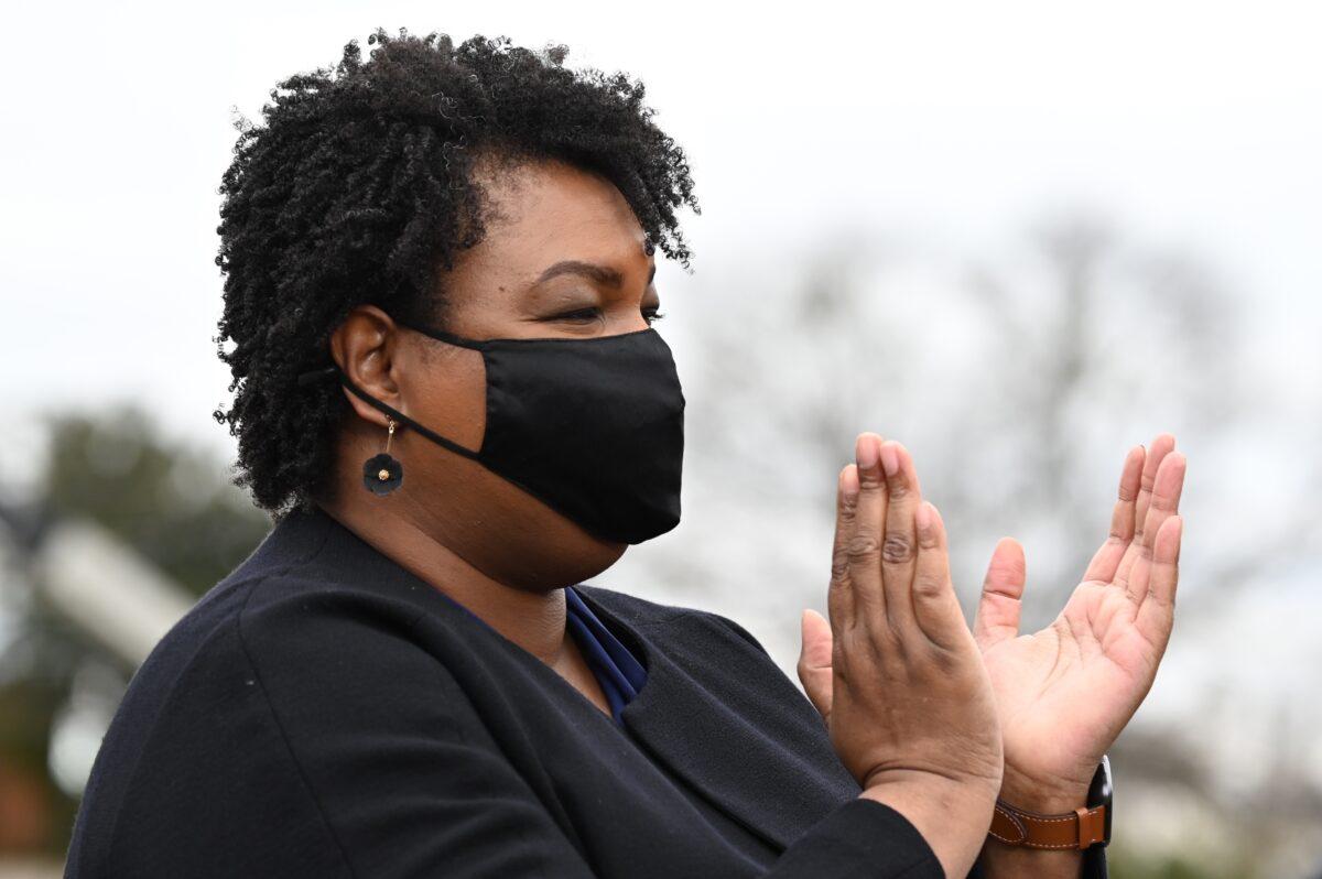 Stacey Abrams claps as she watches Democratic Senate candidates speak during a campaign rally in Atlanta, Ga., on Dec. 15, 2020. (Jim Watson/AFP via Getty Images)