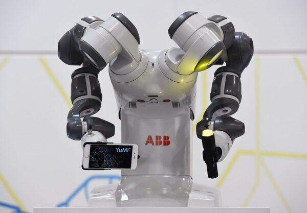 Collaborative dual-arm robot YuMi holds a smartphone and a torch at the Swiss automation group ABB booth at the Hannover Messe industrial trade fair in Hanover, Germany, on April 13, 2015. (TOBIAS SCHWARZ/AFP via Getty Images)