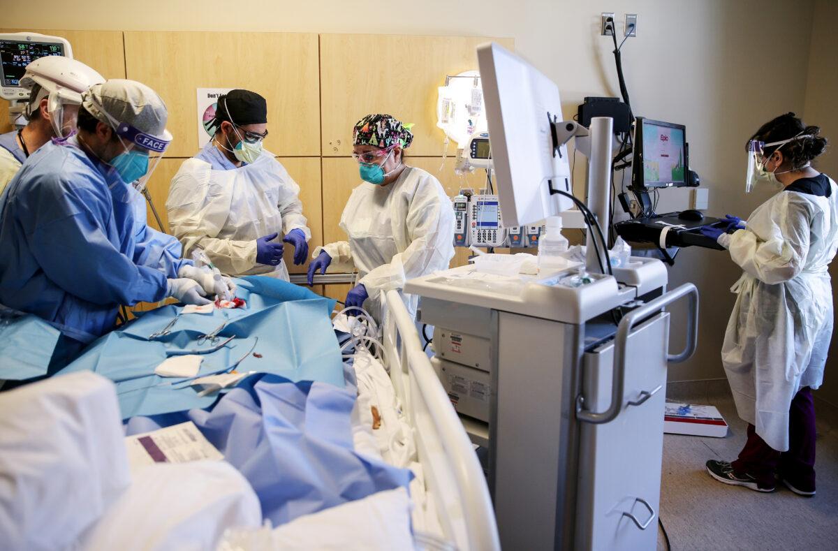 Clinicians perform a tracheostomy on a patient in a COVID-19 intensive care unit at Providence Holy Cross Medical Center in Los Angeles, Calif., on Feb. 17, 2021. (Mario Tama/Getty Images)