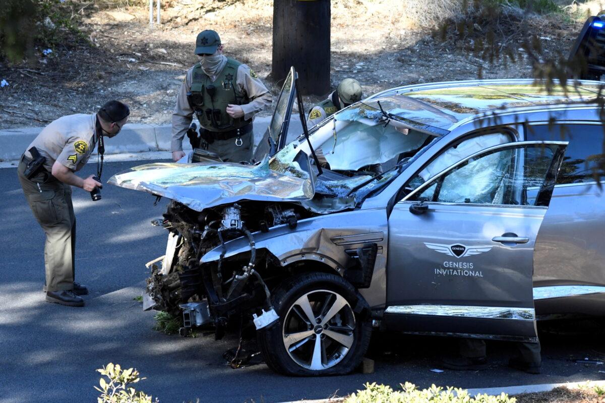 Los Angeles County Sheriff's Deputies inspect the vehicle of golfer Tiger Woods, who was rushed to hospital after suffering multiple injuries, after it was involved in a single-vehicle accident in Los Angeles, Calif., on Feb. 23, 2021. (Gene Blevins/Reuters)