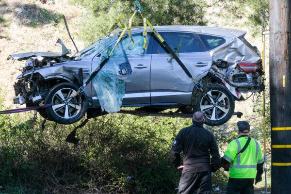 A crane is used to lift a vehicle following a rollover accident involving golfer Tiger Woods in the Rancho Palos Verdes suburb of Los Angeles, Calif., on Feb. 23, 2021. (Ringo H.W. Chiu/AP Photo)