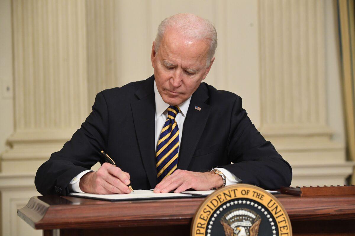 President Joe Biden signs an executive order on securing critical supply chains, in the State Dining Room of the White House in Washington on Feb. 24, 2021. (Saul Loeb/AFP via Getty Images)