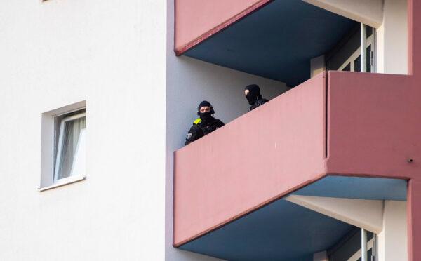 Police officers stand on a balcony of an apartment building during raids against an Islamist network at the Maerkische Viertel neighborhood in Berlin, on Feb. 25, 2021. (Christophe Gateau/DPA via AP)